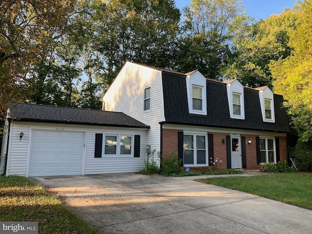 cape cod home with a garage and a front lawn