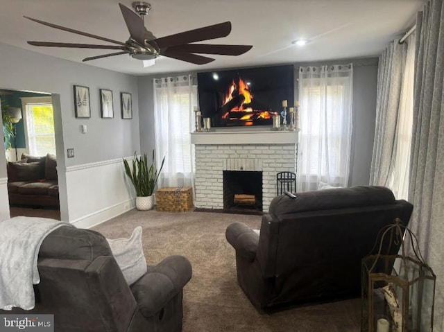 carpeted living area featuring a fireplace and baseboards