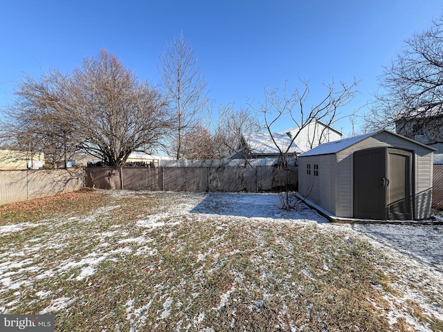 yard layered in snow with a shed