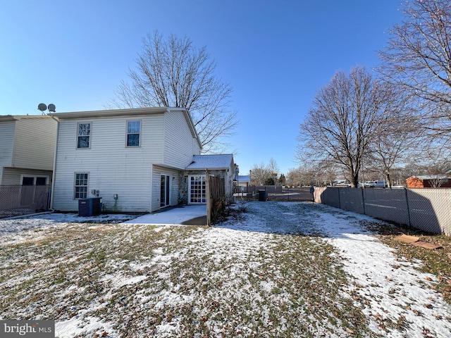 snow covered rear of property featuring a patio and cooling unit