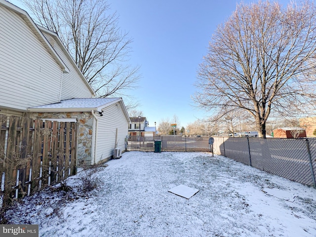 yard covered in snow with central air condition unit