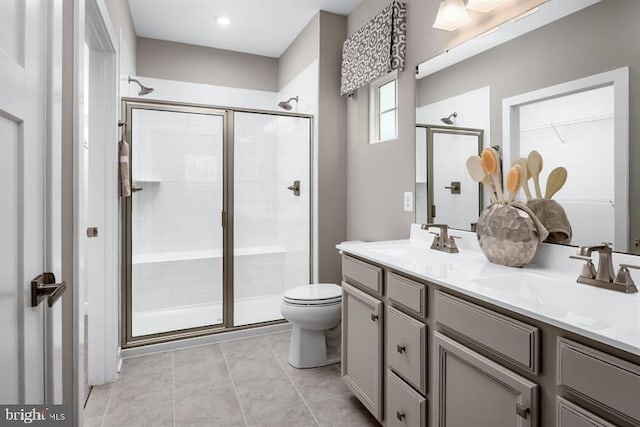 bathroom with vanity, toilet, and a shower with shower door