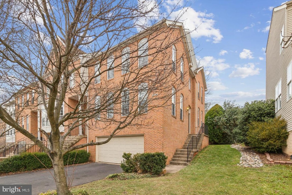 view of side of property featuring a garage and a lawn