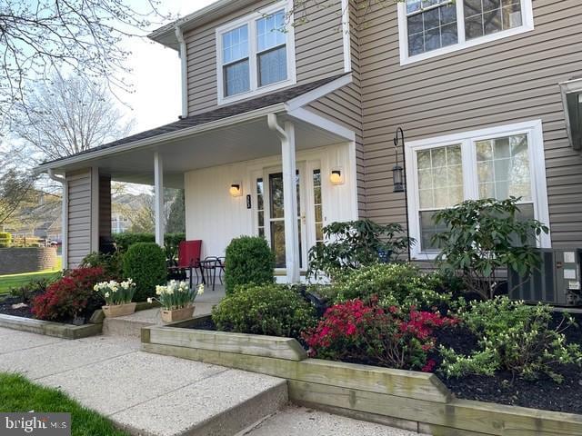 view of exterior entry featuring cooling unit and covered porch