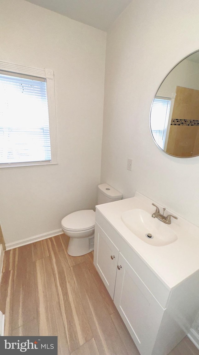 bathroom featuring wood-type flooring, vanity, and toilet