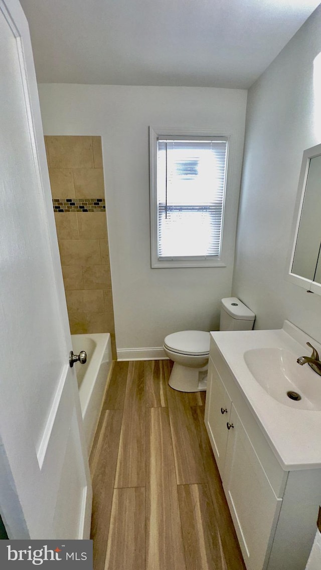 bathroom with vanity, toilet, and hardwood / wood-style floors