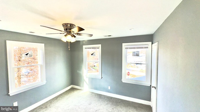 empty room featuring carpet floors, a healthy amount of sunlight, and ceiling fan