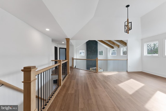 interior space featuring wood-type flooring and lofted ceiling with beams