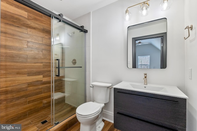 bathroom with hardwood / wood-style flooring, vanity, toilet, and a shower with shower door