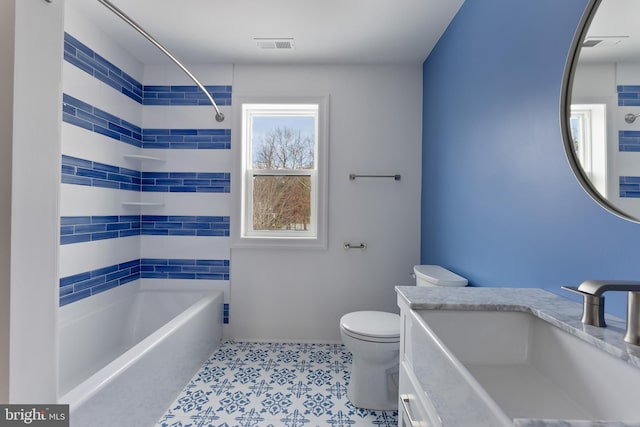 full bathroom featuring tiled shower / bath combo, vanity, and toilet