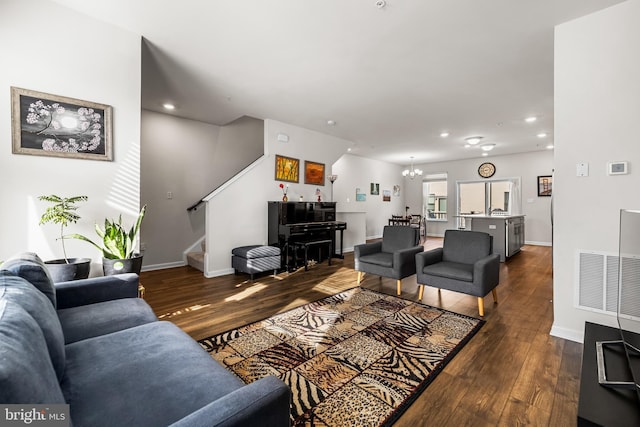 living room with an inviting chandelier and dark hardwood / wood-style flooring