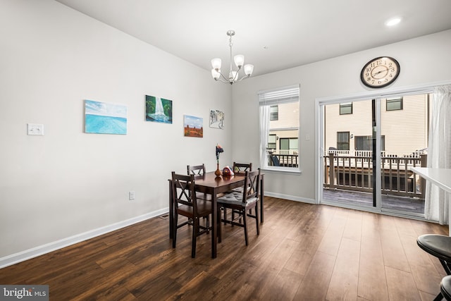 dining space featuring a notable chandelier and dark hardwood / wood-style flooring