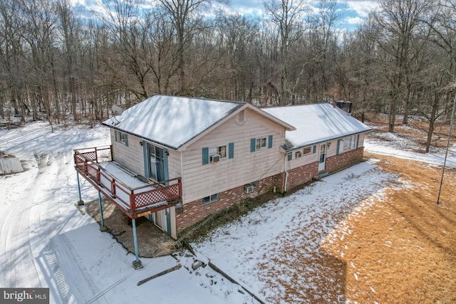 snow covered property with a deck