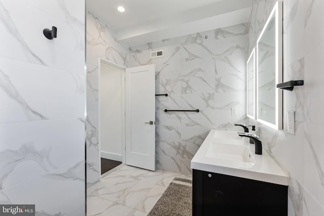 bathroom with vanity and tile walls