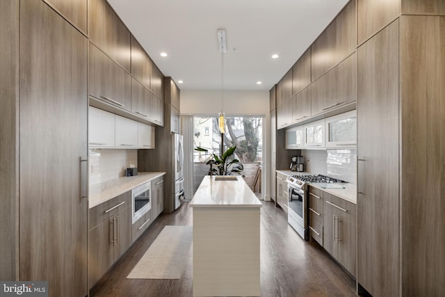 kitchen with dark hardwood / wood-style floors, pendant lighting, backsplash, a center island, and stainless steel appliances