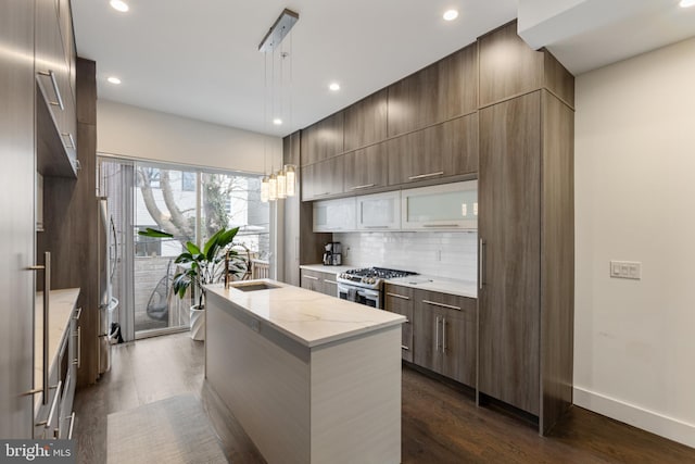 kitchen featuring gas range, tasteful backsplash, decorative light fixtures, a center island, and dark hardwood / wood-style flooring