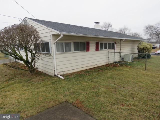 view of property exterior with a yard and central AC