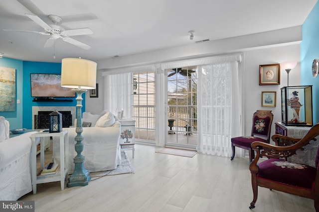 living room with ceiling fan and light wood-type flooring