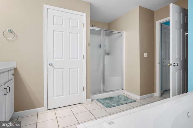 bathroom with tile patterned flooring, vanity, and a shower with door