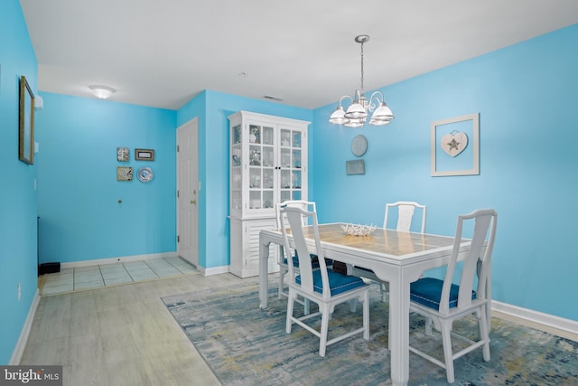 dining area featuring light wood-type flooring and a chandelier