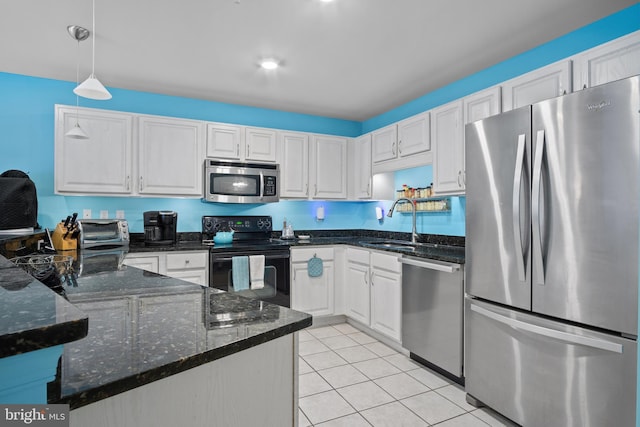 kitchen with sink, dark stone countertops, hanging light fixtures, stainless steel appliances, and white cabinets