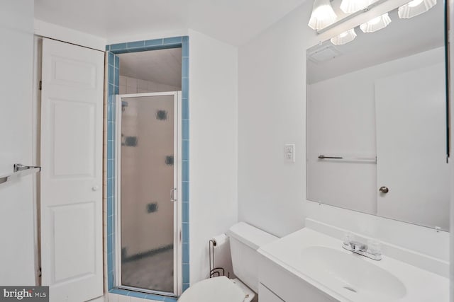 bathroom featuring a stall shower, vanity, and toilet