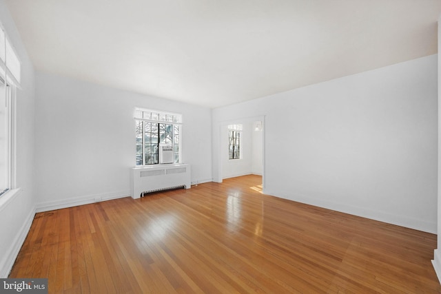 empty room featuring radiator heating unit and light wood-type flooring