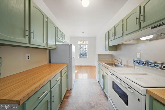 kitchen featuring pendant lighting, sink, fridge, white range with electric stovetop, and green cabinetry