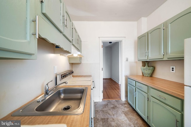 kitchen featuring sink, green cabinets, and range