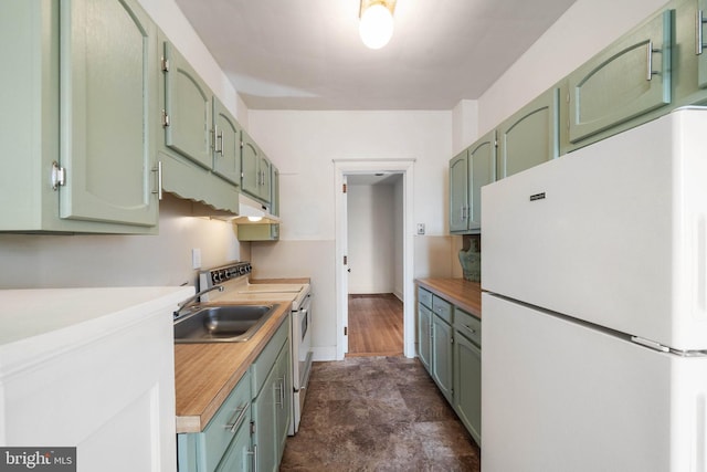 kitchen featuring wood counters, sink, white appliances, and green cabinetry