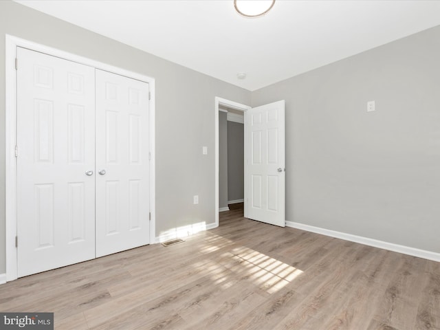 unfurnished bedroom with a closet and light hardwood / wood-style flooring