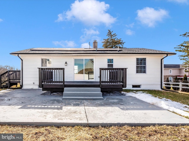 back of property with a deck and a patio area