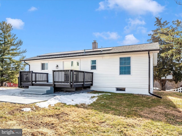 rear view of house with a wooden deck, a lawn, and a patio