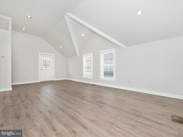 additional living space featuring vaulted ceiling and light hardwood / wood-style flooring