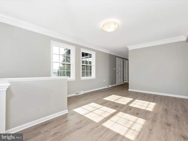 unfurnished room featuring ornamental molding and light hardwood / wood-style floors