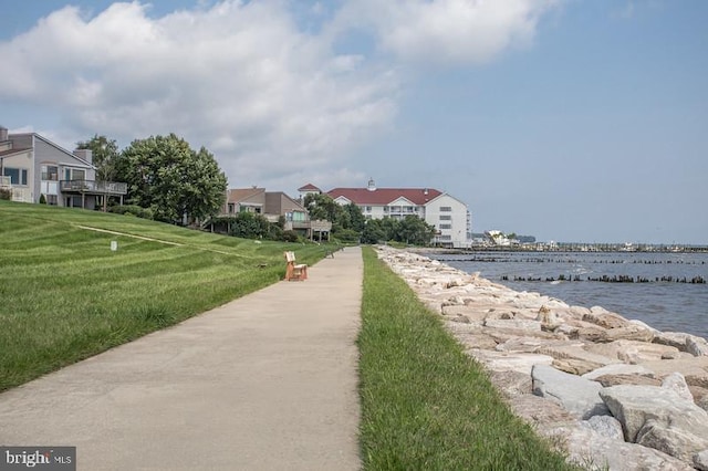 view of community featuring a lawn and a water view