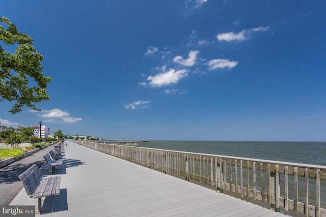 view of dock featuring a water view and a view of the beach