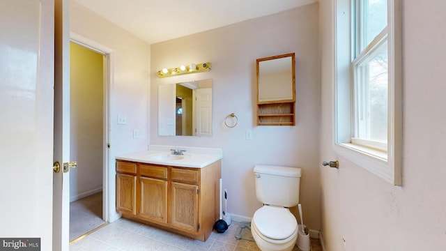 bathroom with vanity, toilet, and baseboards