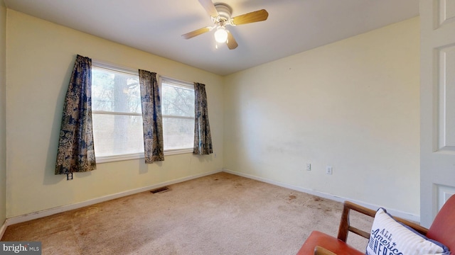 unfurnished room with baseboards, ceiling fan, visible vents, and light colored carpet