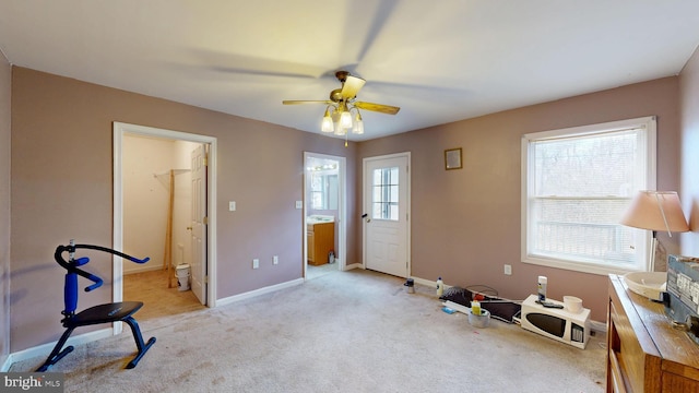 miscellaneous room featuring light carpet, baseboards, and a ceiling fan