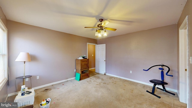 interior space featuring carpet floors, a ceiling fan, and baseboards