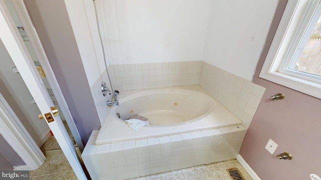 bathroom featuring baseboards and a whirlpool tub