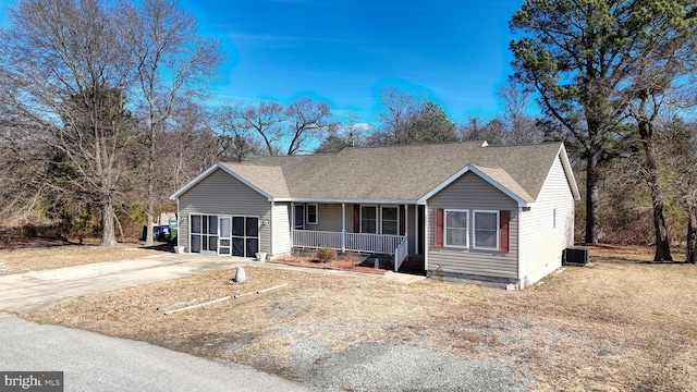 ranch-style house with a porch, central AC, a garage, and roof with shingles