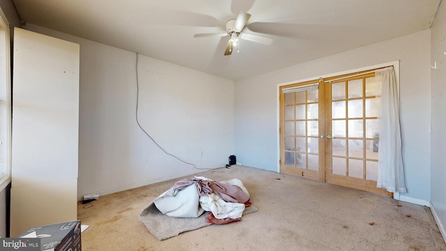 carpeted empty room featuring french doors and a ceiling fan