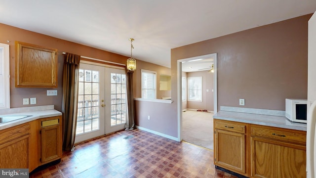 kitchen featuring pendant lighting, french doors, light countertops, white microwave, and tile patterned floors