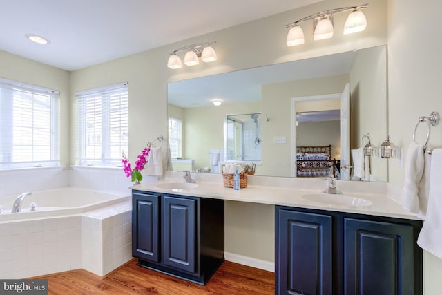 bathroom with vanity, shower with separate bathtub, and hardwood / wood-style floors