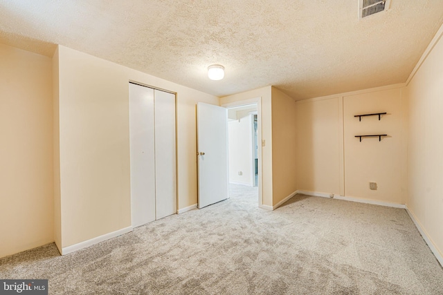 unfurnished room featuring carpet flooring and a textured ceiling