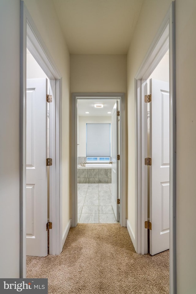 hallway featuring light colored carpet