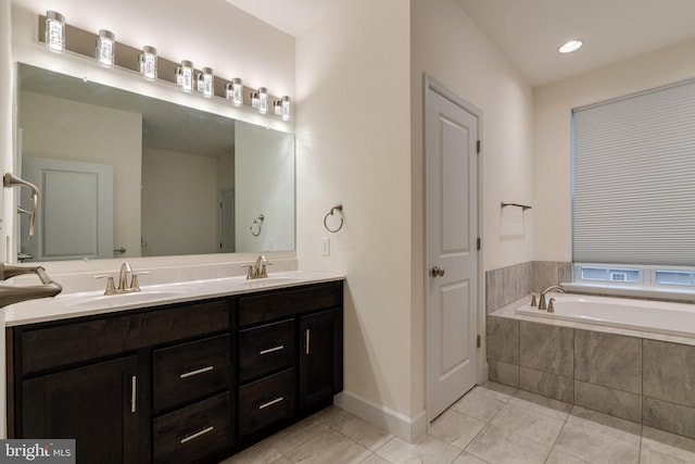 bathroom with vanity, tiled bath, and tile patterned flooring