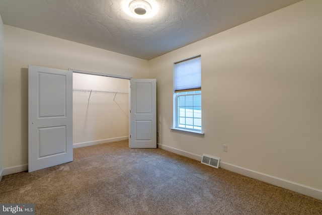 unfurnished bedroom featuring carpet floors, a closet, and a textured ceiling